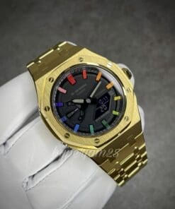 Gold stainless steel Casioak watch featuring a striking black dial and unique rainbow hour markers.