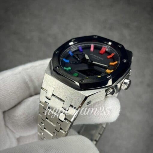 Close-up of a customized Casioak showcasing its vibrant rainbow hour indices, contrasting black bezel, and full stainless steel bracelet.